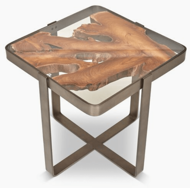 Supported by a galvanized stainless steel framework, the undeniable focal point of this artisan-crafted side table is the solid teak top, which shows off an incredible organic shape beneath a clear glass surface. Due to the use of natural materials, each piece is unique and may vary slightly from image shown.
