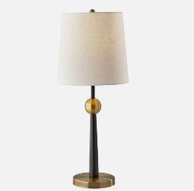 gleaming brass and sleek black finishes gives this table lamp a quiet glamour, while the tapered stem and globe accent nod