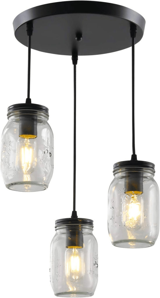 Three‑light farmhouse mason‑jar chandelier with clear glass jars, matte‑black 11.4″ round canopy and height‑adjustable 48″ cords, compatible with E26 bulbs—rustic pendant lighting for kitchen islands, dining rooms and hallways.