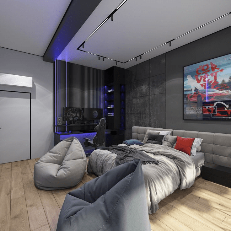 “Modern gaming bedroom with gray padded bed, LED accent lighting, dual-monitor gaming desk, bean bag chairs, and racing car wall art on a dark feature wall.”