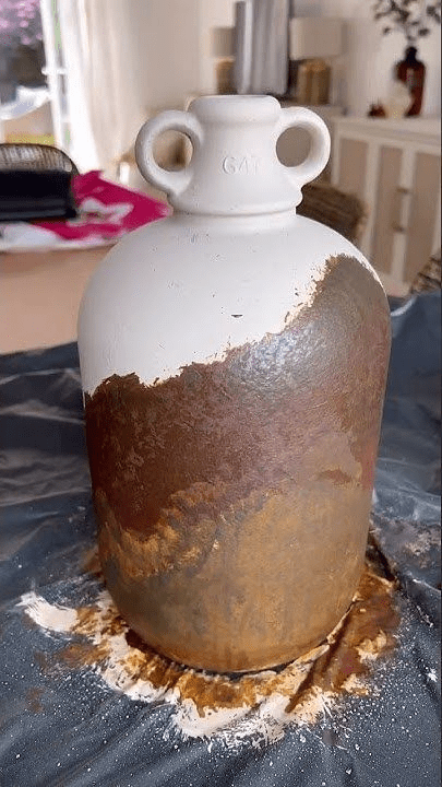 "DIY ceramic vase makeover with a faux rust finish technique, transforming a plain white jug into a vintage rustic decor piece."