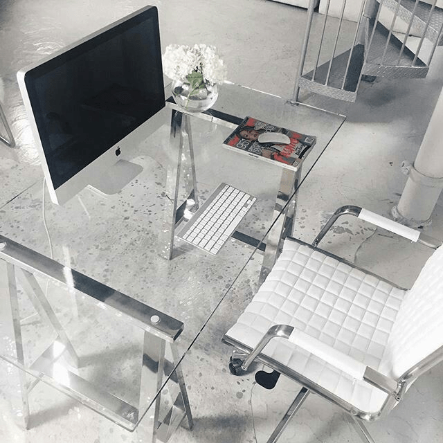 “Clean minimalist workspace with glass computer desk, iMac, white office chair, and simple desk styling for a modern home office.”