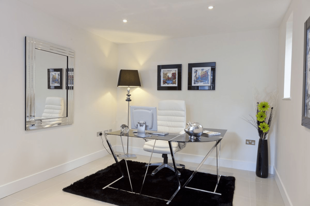 “Luxury modern office design with glass desk, white desk chair, framed artwork, black floor lamp, and sleek monochrome home office aesthetic.”