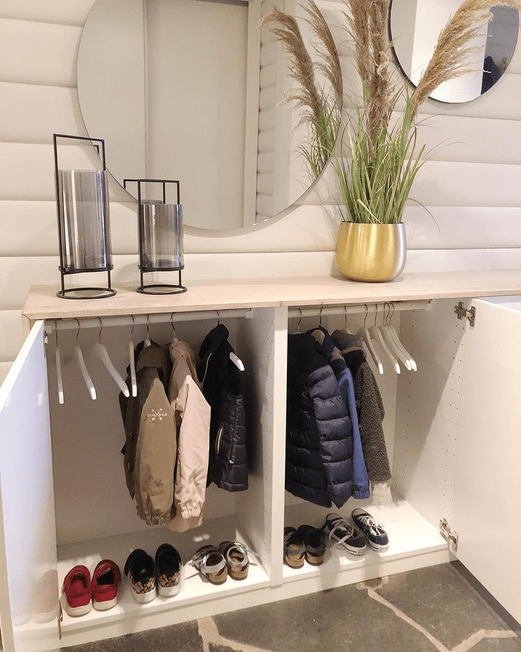 “Minimalist entryway mudroom storage cabinet with hanging kids coats, shoe organizer, round wall mirror, and neutral decor.”