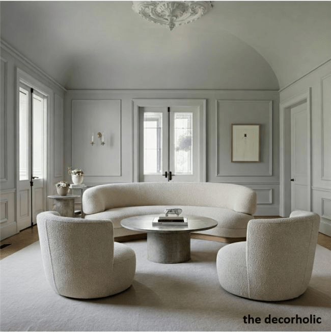 Pastel color drenching minimalist luxury living room with boucle curved sofa, rounded chairs, plaster walls and stone table